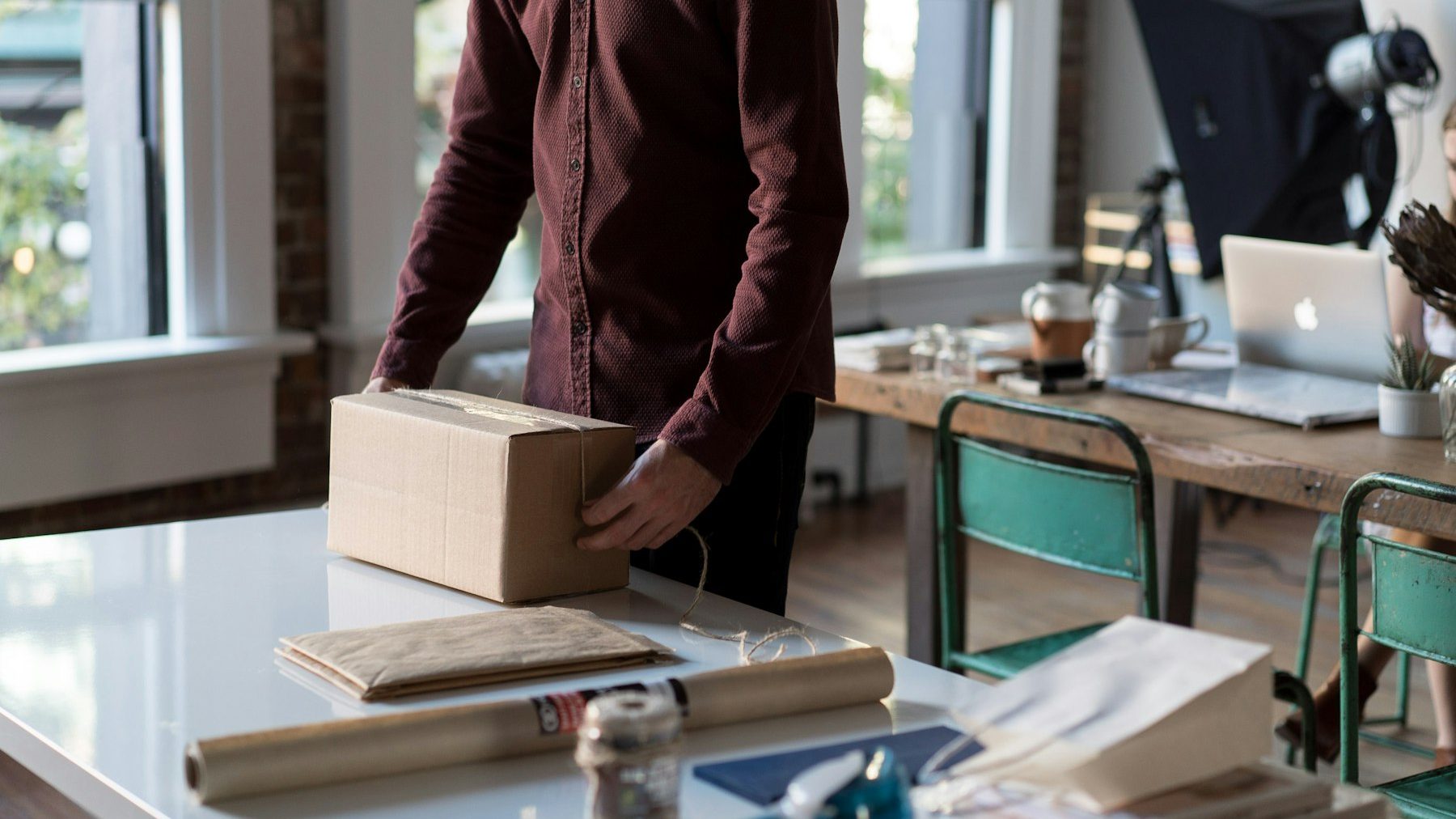 OpenCart to Shopify migration: a person holding a cardboard box on a table