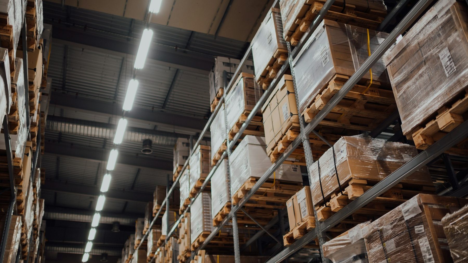 Shopify data migration: brown cardboard boxes on a white metal warehouse rack
