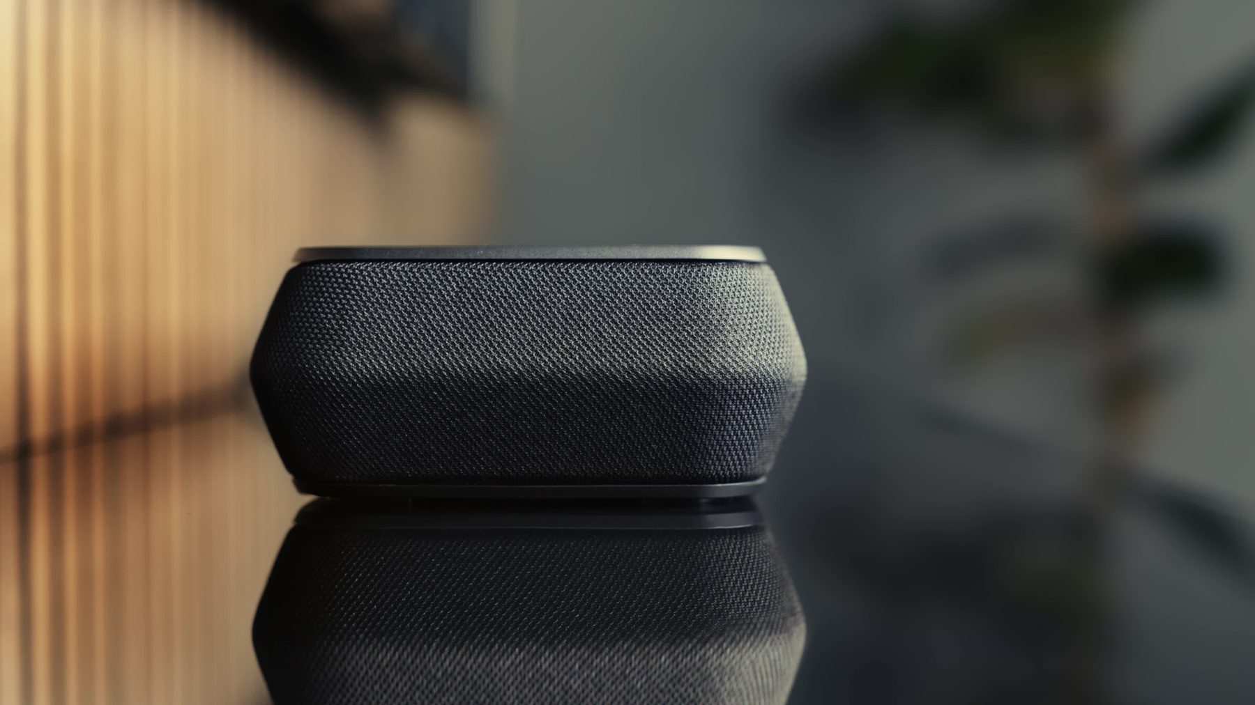 Shopify migration cost: close-up of a premium wireless speaker on a reflective surface